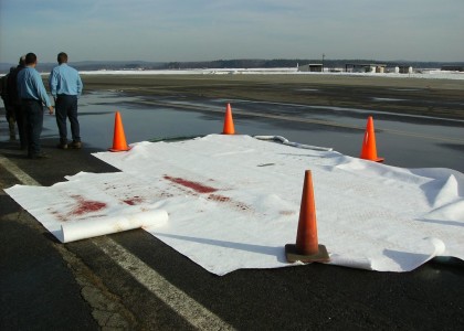 Absorbent material deployed on a paved surface